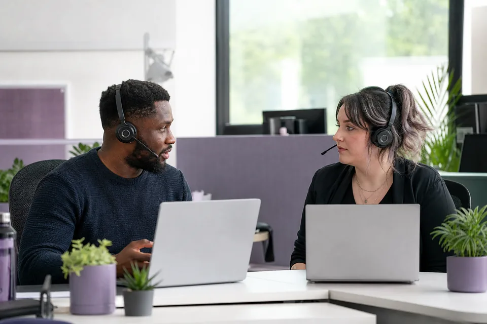 Two moderators reviewing a policy decision together at a shared desk